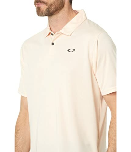 Man wearing beige polo shirt with logo