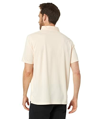 Man wearing a cream-colored polo shirt, viewed from the back.