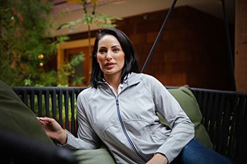 Woman sitting on an outdoor swing with cushions.